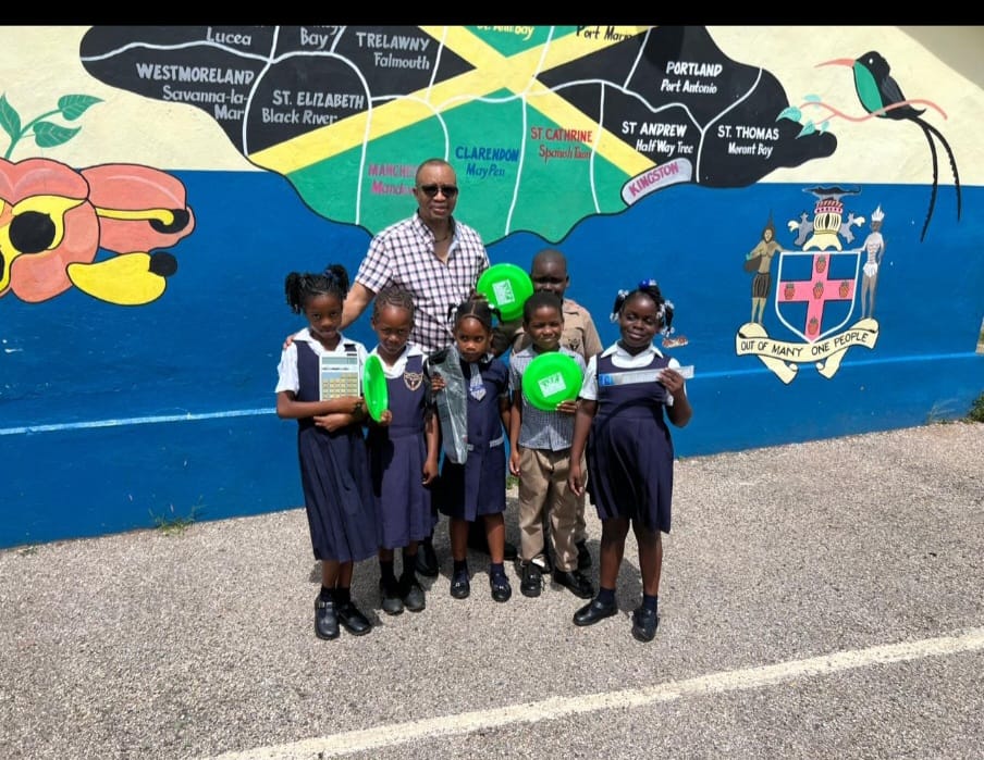 Vassell O'Gilvie, Vice President of Friends of Porus, with primary school students in Porus holding donated school supplies